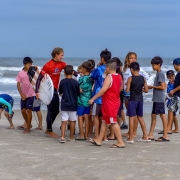 A dupla de surfistas orientando as crianças na praia