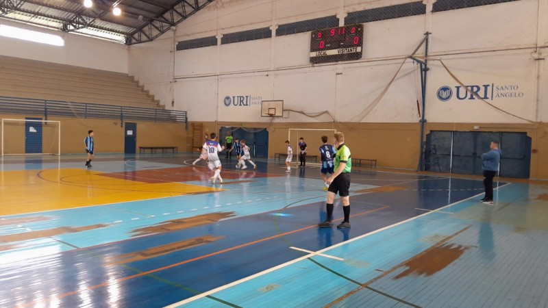Jovens jogam futsal em ginásio