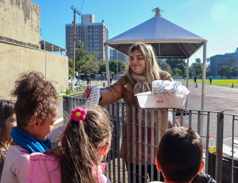 Diretora distribui pipoca enquanto crianças esperam